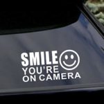 (2 Pack) 7″x3.5″ White – Smile You’re On Camera – UV Resistant, Waterproof, Peel & Stick Decor Decal Sticker Quote Adhesive Vinyl Mural Art Script Lettering – For storefronts, cars, trucks, boats, etc
